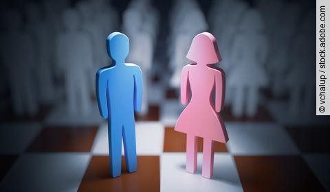 rosa weibliche Holzfigur und blaue männliche Holzfigur auf einem Schachbrett