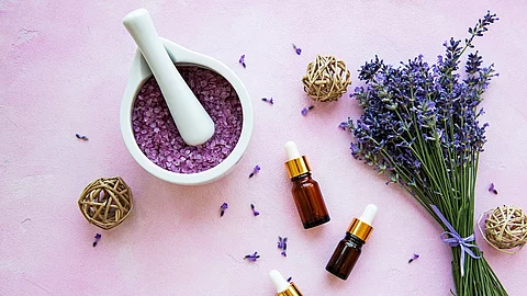 Komposition aus Lavendelstrauß und Aromaölfläschchen.