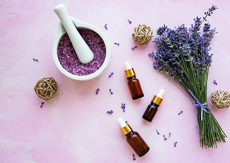 Komposition aus Lavendelstrauß und Aromaölfläschchen.