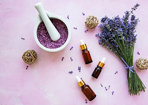 Komposition aus Lavendelstrauß und Aromaölfläschchen.