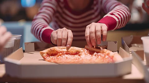 Junge Frau isst Pizza
