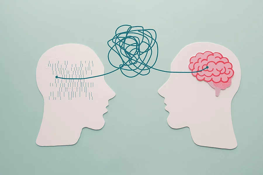 Illustration: 2 ausgeschnittene Papierköpfe verbunden durch ein Knäuel