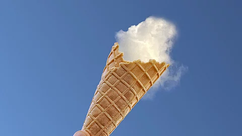 Eiswaffel vor dem blauen Himmel und eine Wolke als "Eiskugel".