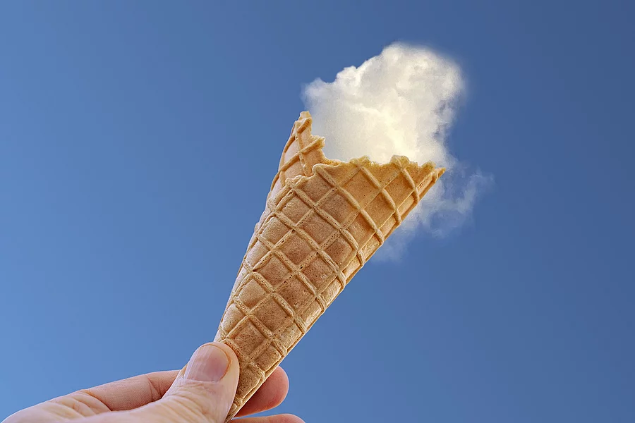 Eiswaffel vor dem blauen Himmel und eine Wolke als "Eiskugel".