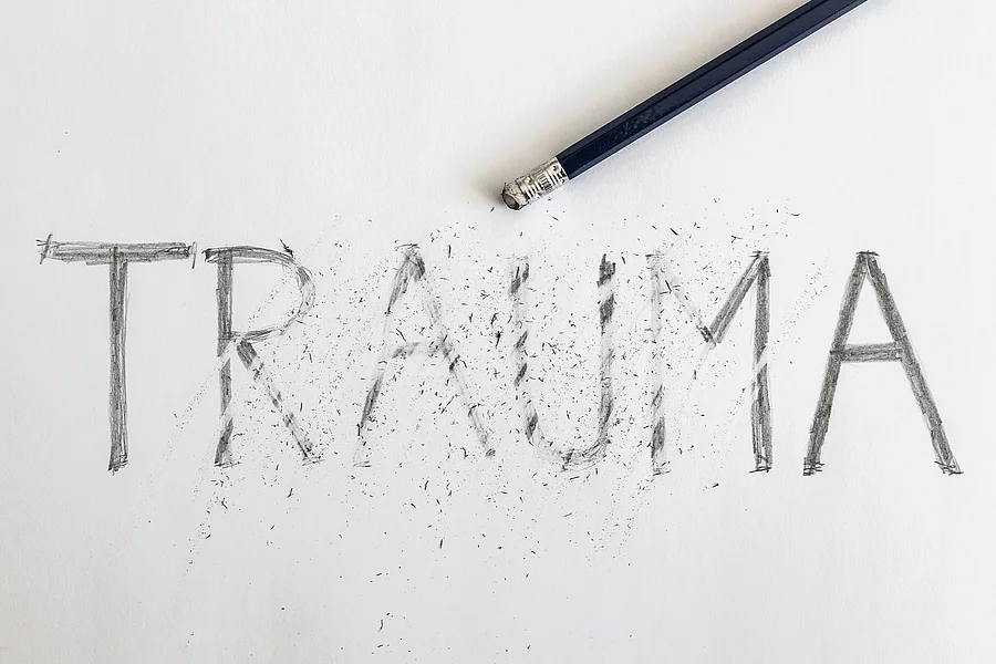 Erasing trauma. Trauma written on white paper with a pencil, par Bleistift radiert die Schrift "Trauma" weg