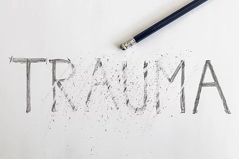 Bleistift radiert die Schrift "Trauma" weg