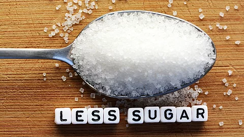 Löffel mit Zucker und der Unterschrift "less sugar"