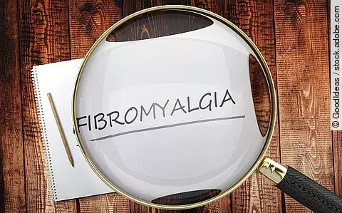 Zettel mit Aufschrift Fibromyalgie unter einer Lupe