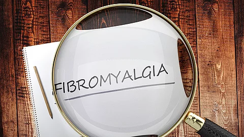 Zettel mit Aufschrift Fibromyalgie unter einer Lupe