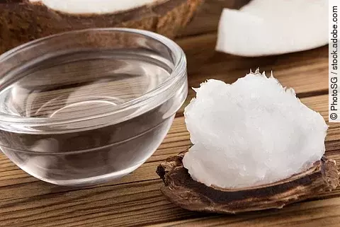 Kokosöl und Kokosnuss auf Holzuntergrund