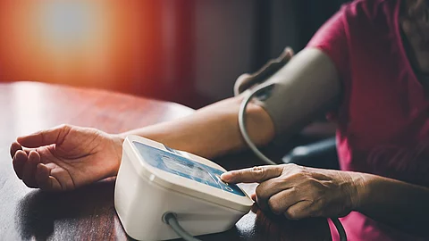 Elder woman upper arm bicep in cuff. Older retired lady measuring manually blood pressure, using digital tonometer machine at home. Healthcare, disease treatment concept. Ältere Frau misst ihren Blutdruck
