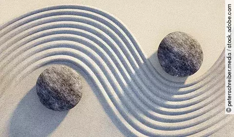 Steine Yin Yang im Sand.