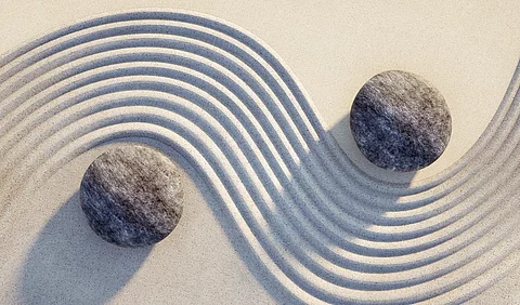 Steine Yin Yang im Sand.