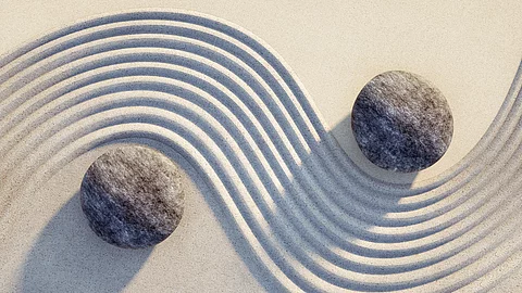 Steine Yin Yang im Sand.
