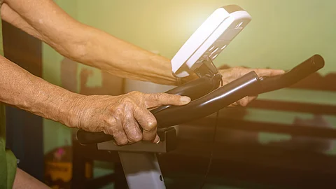 Hände eines Mannes auf einem Ergometer