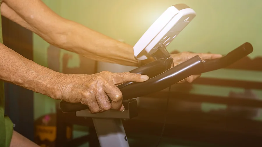 Hände eines Mannes auf einem Ergometer Hände eines Mannes auf einem Ergometer
