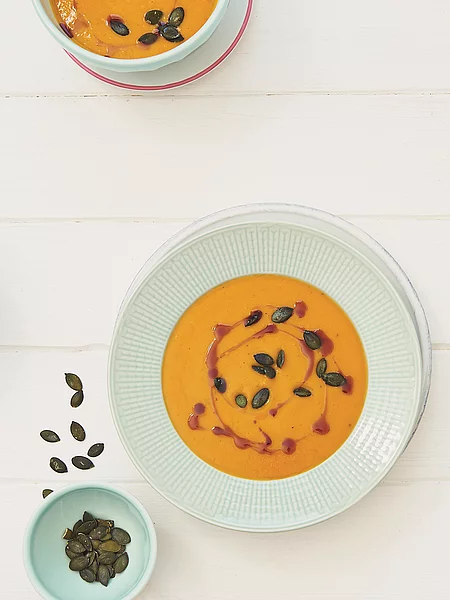 Kürbissuppe angerichtet mit gerösteten Kürbiskernen.