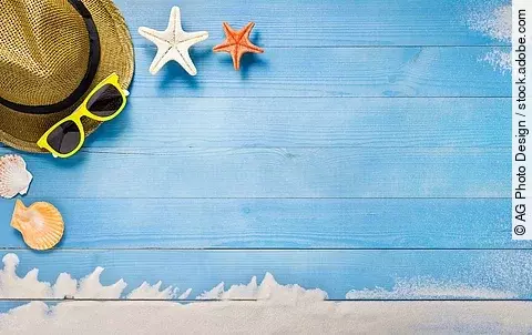 Sonnenhut, Sonnenbrille und Seesterne auf Holzunterlage