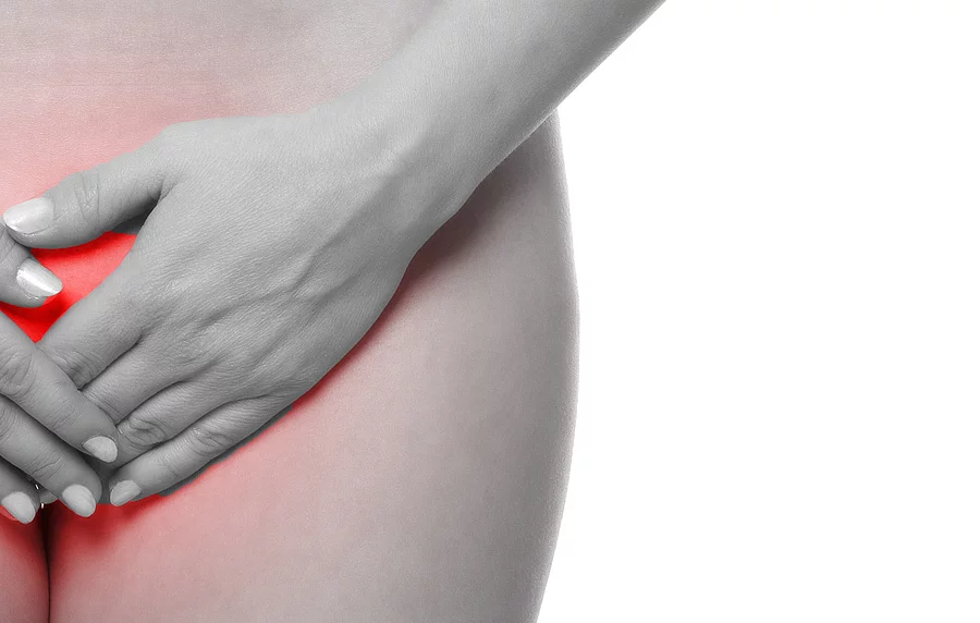 Frau hält sich die Hände über den Unterbauch
