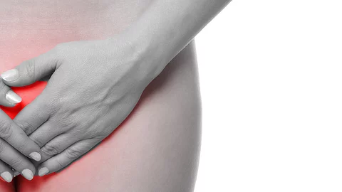 Frau hält sich die Hände über den Unterbauch