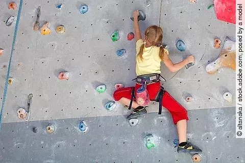 Mädchen klettert in der Kletterhalle