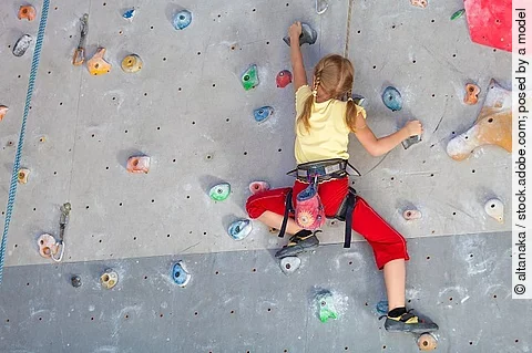 Mädchen klettert in der Kletterhalle