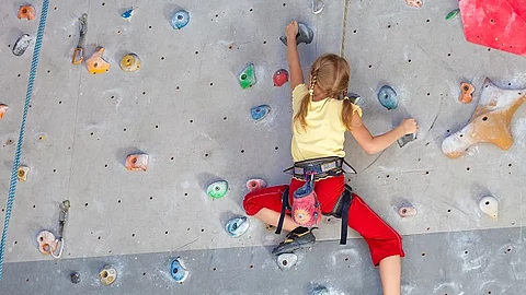 Mädchen klettert in der Kletterhalle