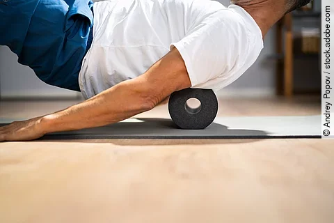 Mann macht eine Übung auf der Faszienrolle.