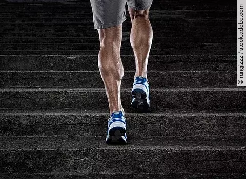 Training, muskulöse Männerbeine beim Treppenlauf