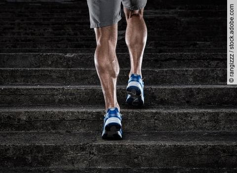 Training, muskulöse Männerbeine beim Treppenlauf