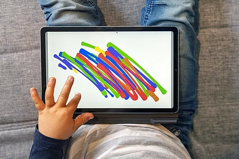 Kind malt auf dem Tablet