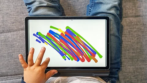 Kind malt auf dem Tablet