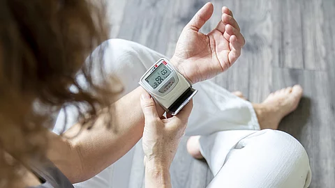 Frau misst Blutdruck am Handgelenk