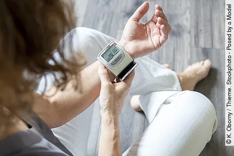 Frau misst Blutdruck am Handgelenk