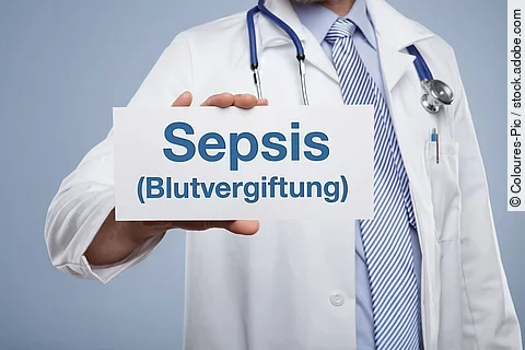 Ein Arzt hält ein Schild in der Hand auf dem Sepsis (Blutvergiftung) steht. 