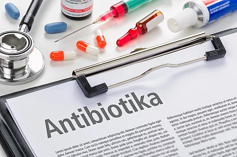 Klemmbock mit Zeitschriftenartikel: Überschrift Antibiotika, daneben Spritzen und Pillen