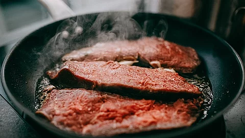 Fleisch wird in Pfanne angebraten. 