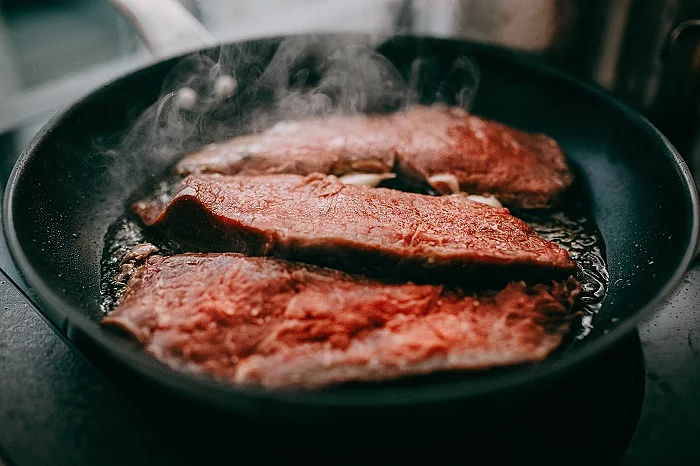 Fleisch wird in Pfanne angebraten. 