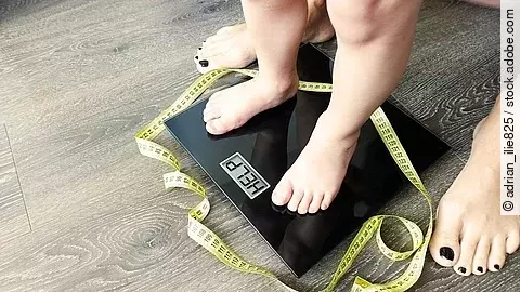 Kinderfüße auf einer Waage, die Waage zeigt: Help