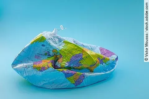 Luftleerer Ball, der mit einer Weltkarte bedruckt ist. 