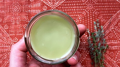 Selbstgemachte Salbe aus Thymian in einem Tiegel