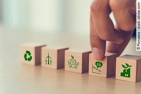 Holzwürfel mit Symbolen, die zum Klimawandel passen (CO2, Flugzeug, etc.)