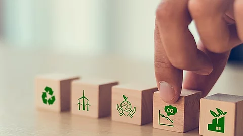Holzwürfel mit Symbolen, die zum Klimawandel passen (CO2, Flugzeug, etc.)