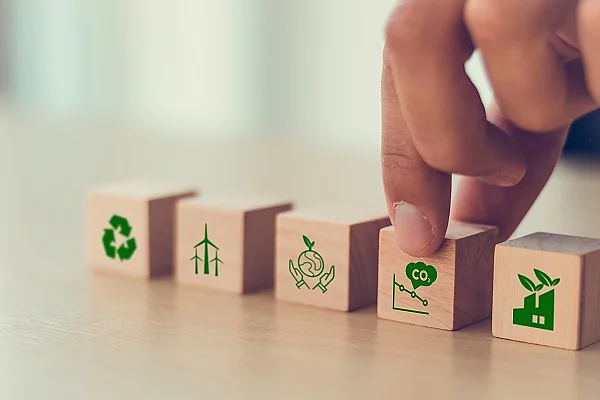 Holzwürfel mit Symbolen, die zum Klimawandel passen (CO2, Flugzeug, etc.)
