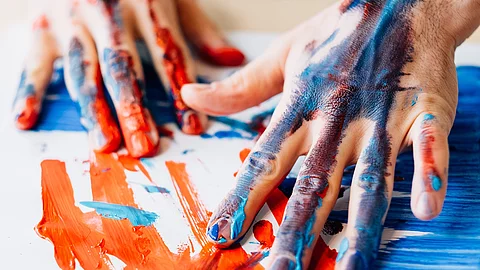 Menschliche Hände malen Farbe auf Papier