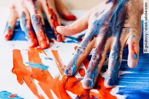 Menschliche Hände malen Farbe auf Papier