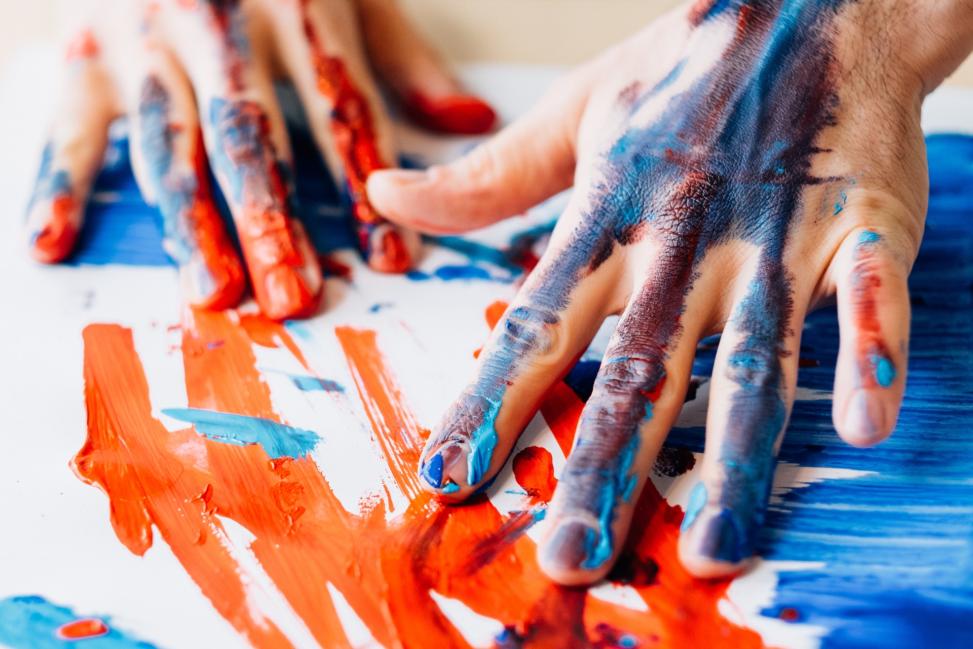 Menschliche Hände malen Farbe auf Papier