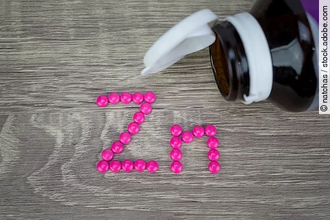 Rosafarbene Tabletten zum Schriftzug Zn gelegt.