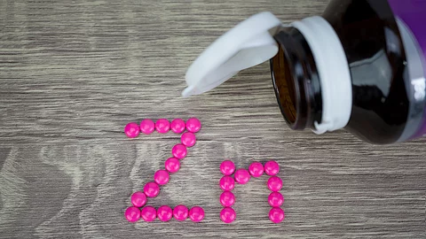 Rosafarbene Tabletten zum Schriftzug Zn gelegt.