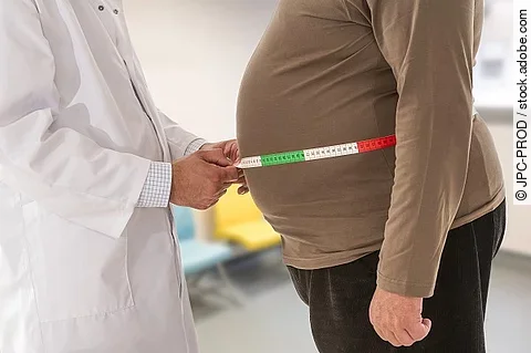 Arzt misst Bauchumfang bei adipösem Patienten.